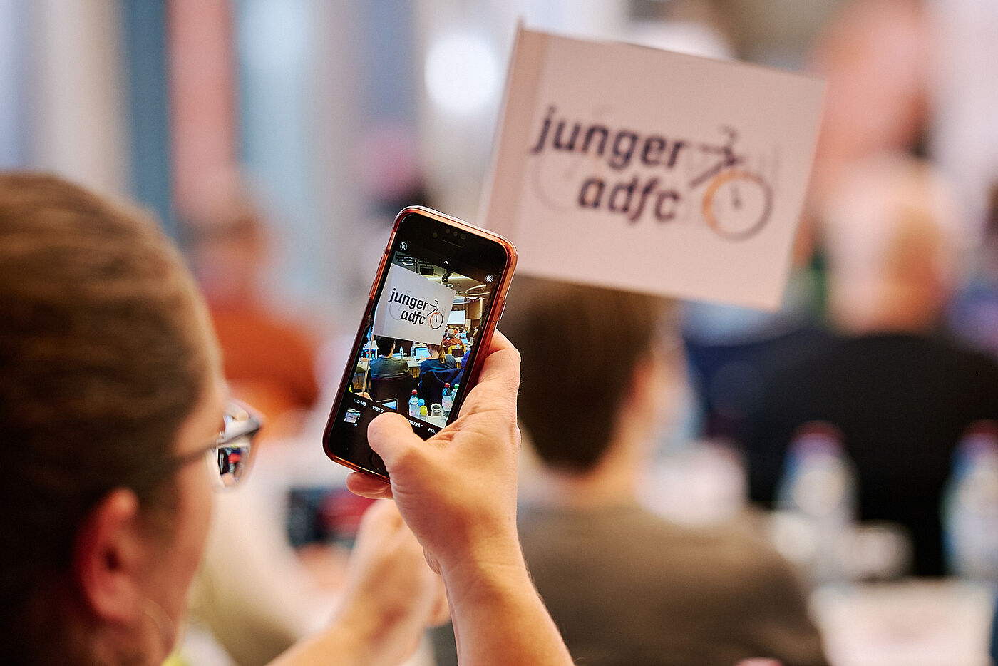 Impression von der ADFC-Bundeshauptversammlung 2024 Person macht Foto mit dem Smartphone von der Veranstaltung