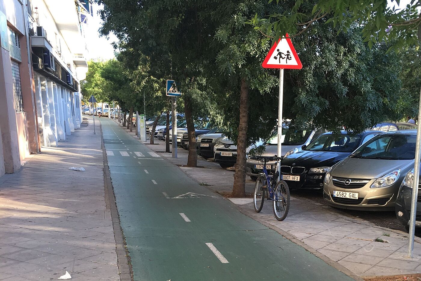 Grün markierter Zweirichtungsradweg zwischen Gehweg und Parksteifen in Sevilla. Grün markierter Zweirichtungsradweg zwischen Gehweg und Parksteifen in Sevilla.