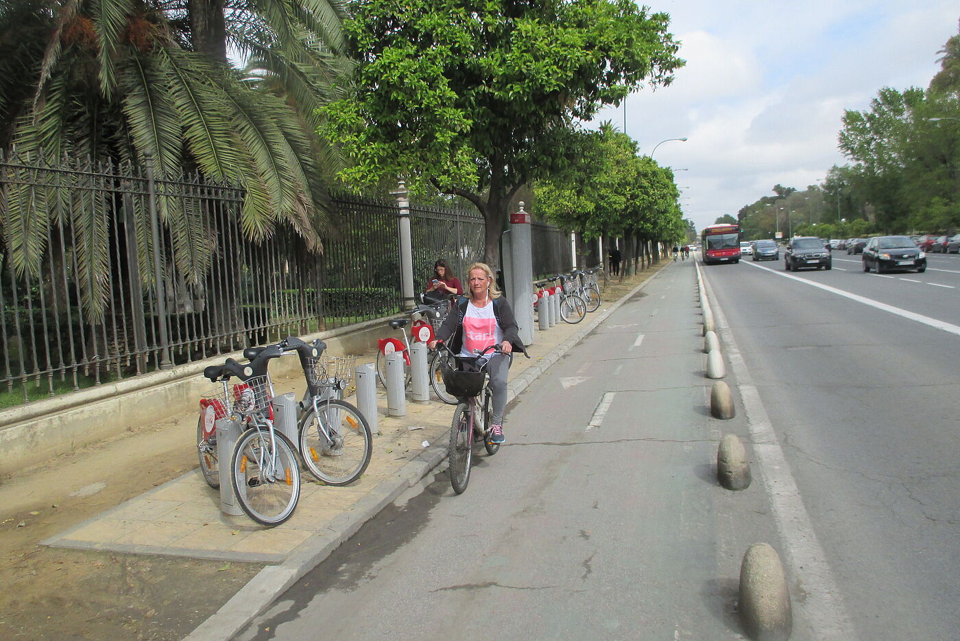 Zweirichtungradweg entlang einer Hauptstraße mit Poller getrennt und Leihrädern. Zweirichtungradweg entlang einer Hauptstraße mit Poller getrennt und Leihrädern.